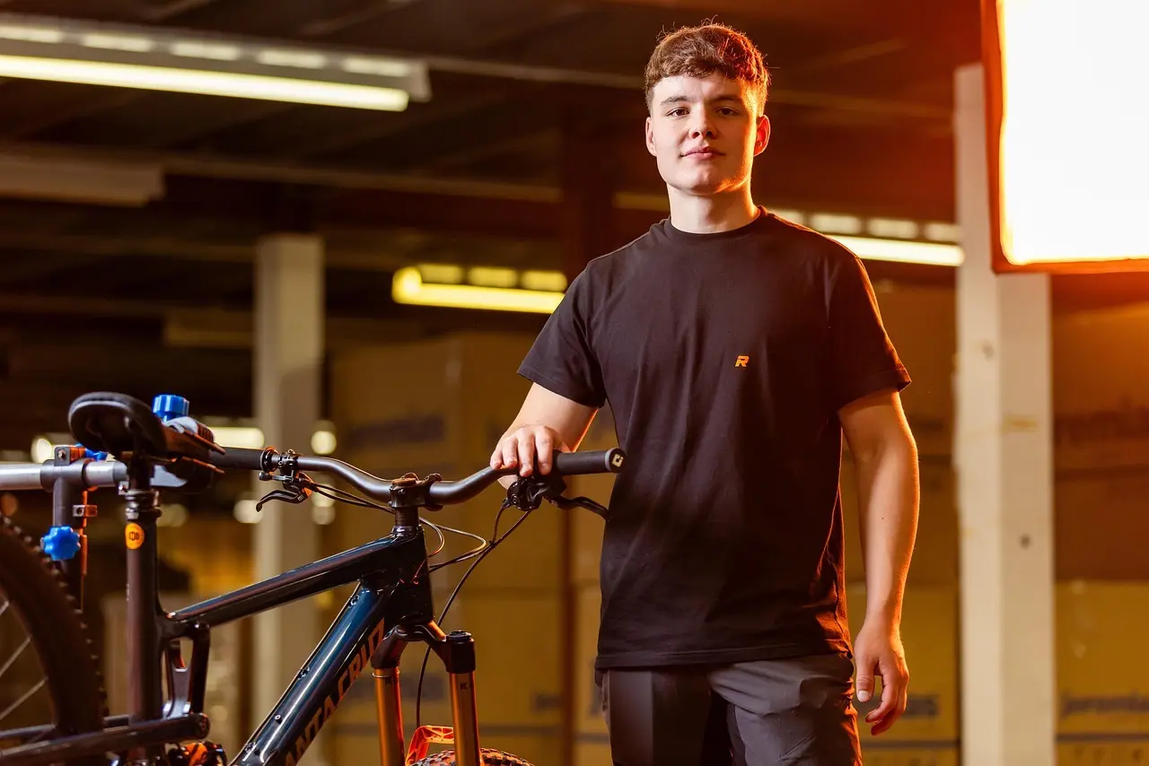 Ung mand ved en mountainbike i et værksted